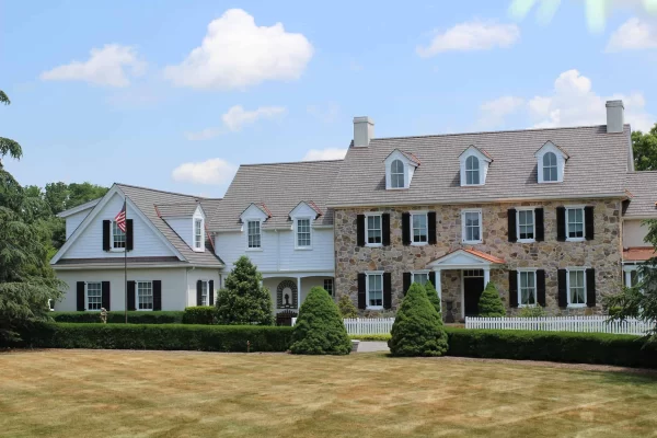Front view of a stone home with an Enviroshake Aged Cedar composite cedar shake roof.