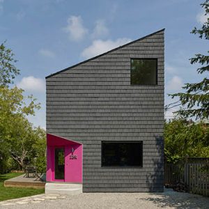 Angular home with pink door and Enviroshake Aged Cedar being used as siding