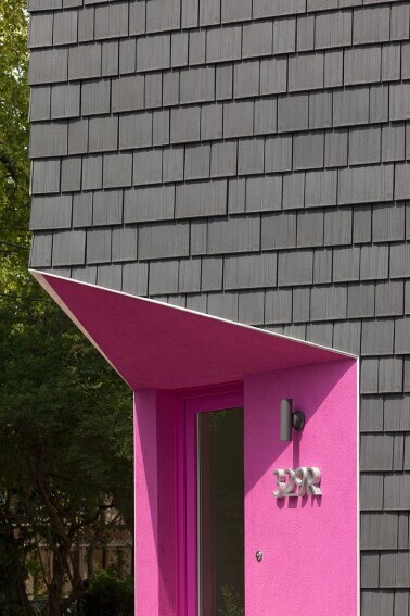 Angular home with pink door and Enviroshake Aged Cedar being used as siding