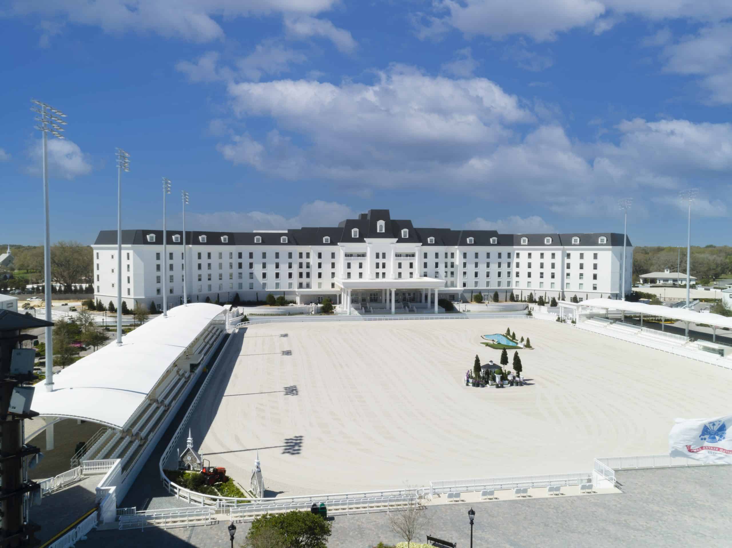 Full view of equestrian hotel with white siding and an Onyx Black Enviroslate composite slate roof