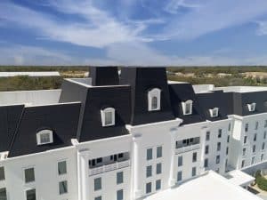 Equestrian hotel with white siding and an Onyx Black Enviroslate composite slate roof