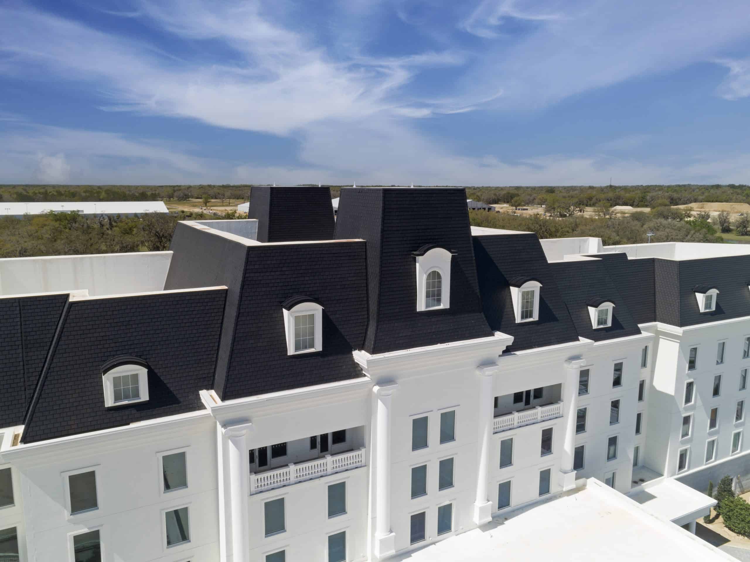 Equestrian hotel with white siding and an Onyx Black Enviroslate composite slate roof