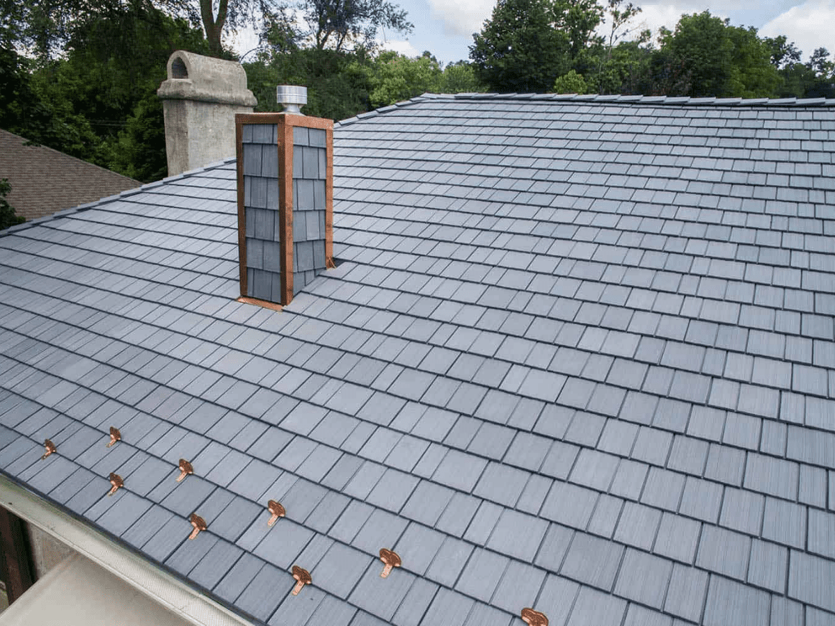 Expansive residential roof with Enviroshake synthetic shingles installed alongside copper snow guards