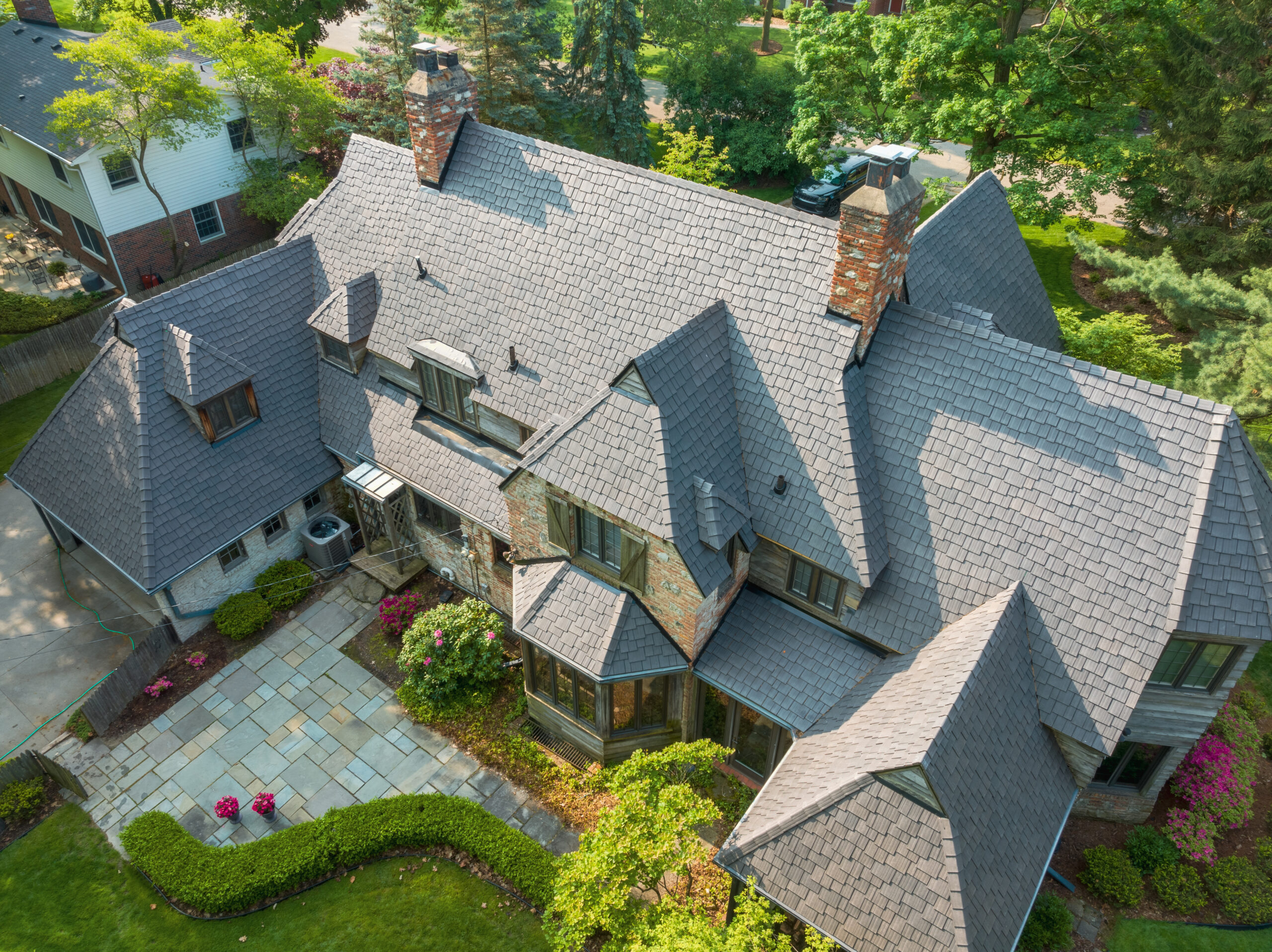 Aerial view of a home in a rustic setting with an Enviroshake Aged Cedar roof where the tiles are offset in a staggered pattern