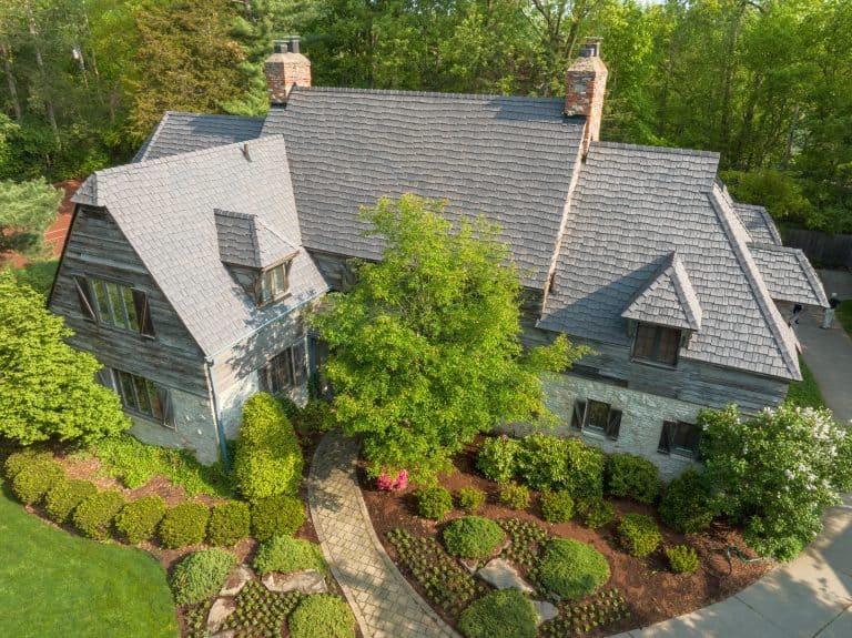 Aerial view of a home in a rustic setting with an Enviroshake Aged Cedar roof where the tiles are offset in a staggered pattern